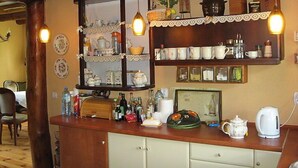 A kitchen with wooden cabinets, a countertop with various kitchen items, and hanging pendant lights. - Marylin by Interhome (Marylin)