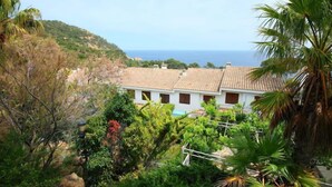A coastal villa with a tiled roof, surrounded by lush greenery and overlooking the sea. - Vacation home Zen by Interhome (Tossa de Mar)
