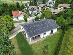 A residential area with a house featuring a solar panel roof.