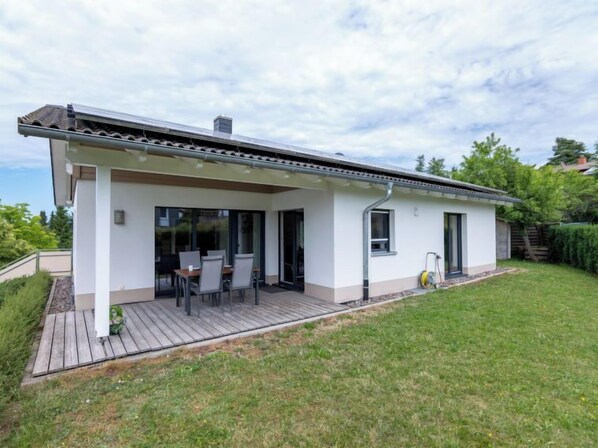 A modern single-story house with a covered patio and a small garden.