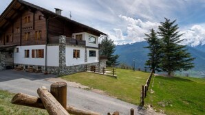 A two-story wooden lodge with stone accents, a stone staircase, and a view of mountains. - Hérisson by Interhome (Sarre)