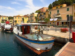 A boat docked at a marina with a wooden deck and a small cabin.