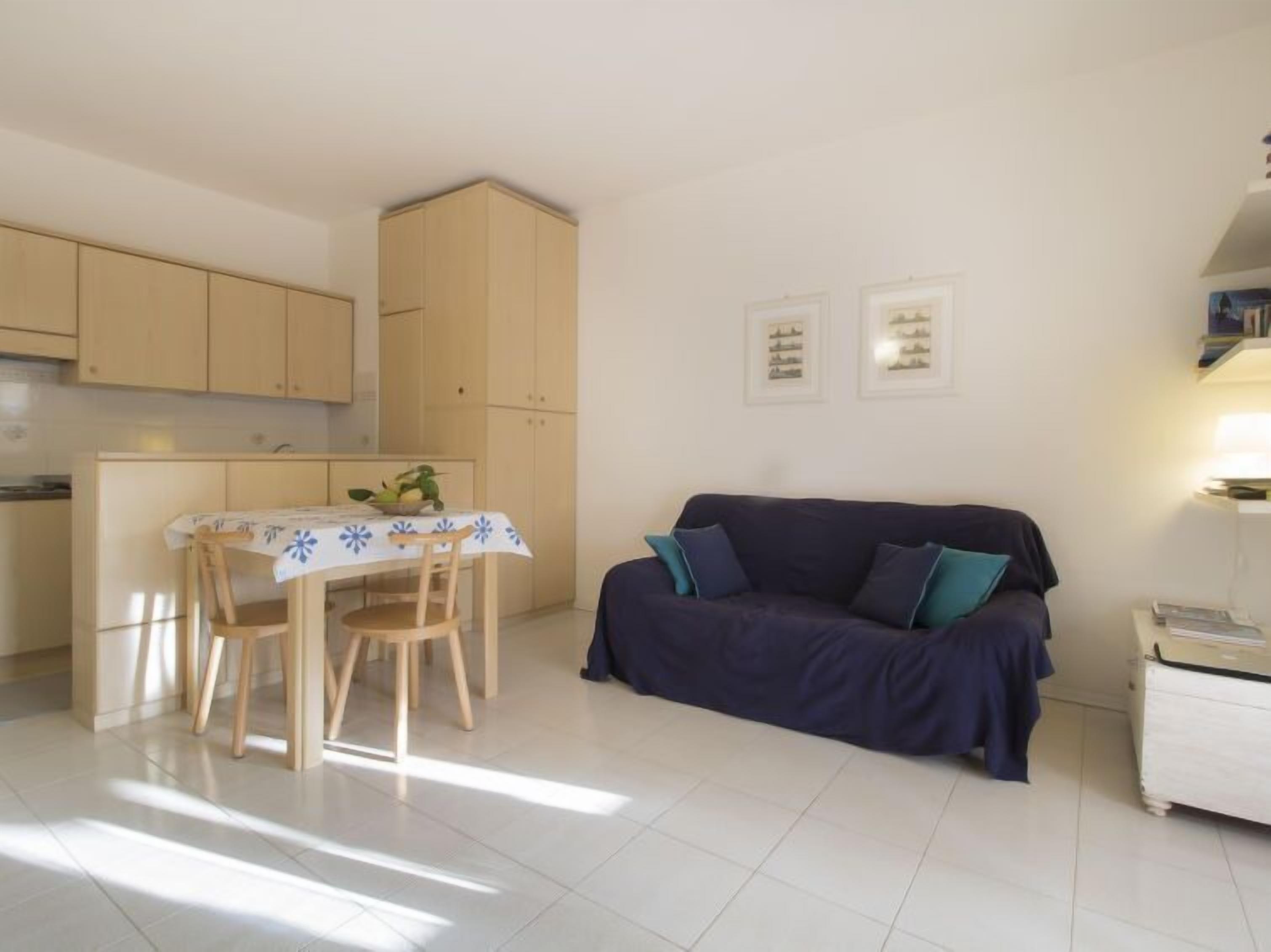 Un espacio habitable compacto con comedor, sofá y una pequeña kitchenette.