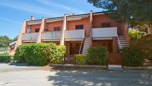 A multi-story building with a flat roof, balconies, and a staircase leading to the upper floors.
