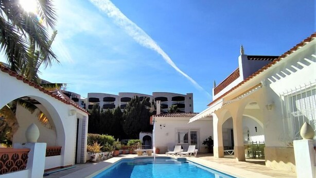 A swimming pool with lounge chairs, white buildings, and a clear sky. - Vacation home Alan by Interhome (Albir)