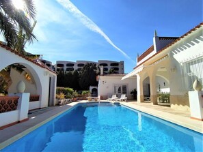 A swimming pool with lounge chairs, white buildings, and a clear sky. - Vacation home Alan by Interhome (Albir)
