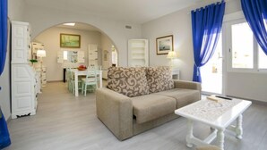 A spacious living area with a sofa, a coffee table, and a dining area with a table and chairs. - Vacation home Alan by Interhome (Albir)