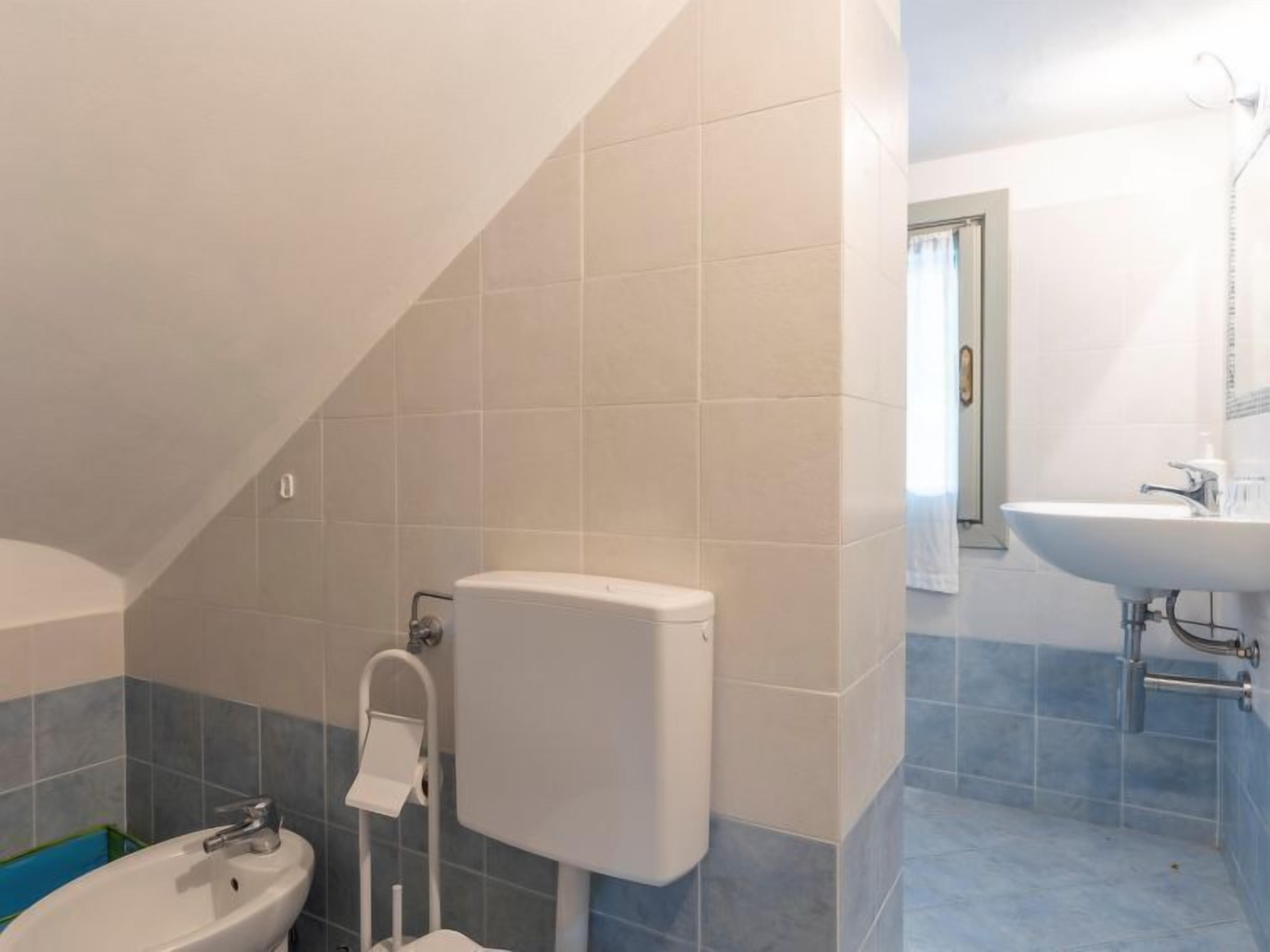 A bathroom with a toilet, bidet, and sink.