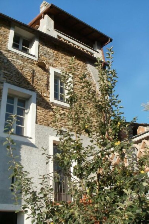 A stone building with multiple windows and a balcony.
