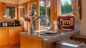 A kitchen with wooden cabinets, a granite countertop, and a wine cooler. - Rêves des Alpes by Interhome (Nendaz)