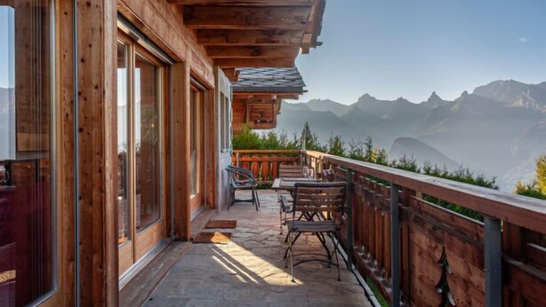 A wooden balcony with a stone floor, overlooking a mountainous landscape. - Rêves des Alpes by Interhome (Nendaz)