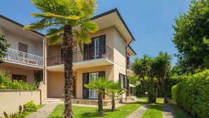 A two-story building with a balcony, surrounded by well-maintained greenery and a stone pathway. - Antonia by Interhome (Marina Pietrasanta)