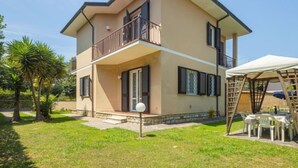 A two-story house with a balcony, a covered outdoor seating area, and a well-maintained lawn. - Antonia by Interhome (Marina Pietrasanta)