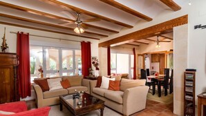 A spacious living room with high ceilings, wooden beams, and a large window. - Villa Mariposa by Interhome (Jávea)