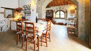 Un coin repas rustique avec des murs en pierre, des meubles en bois et une arche en pierre.