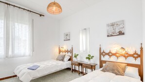 A bedroom with two beds, a desk, and a hanging light fixture. - Alberes by Interhome (Empuriabrava)