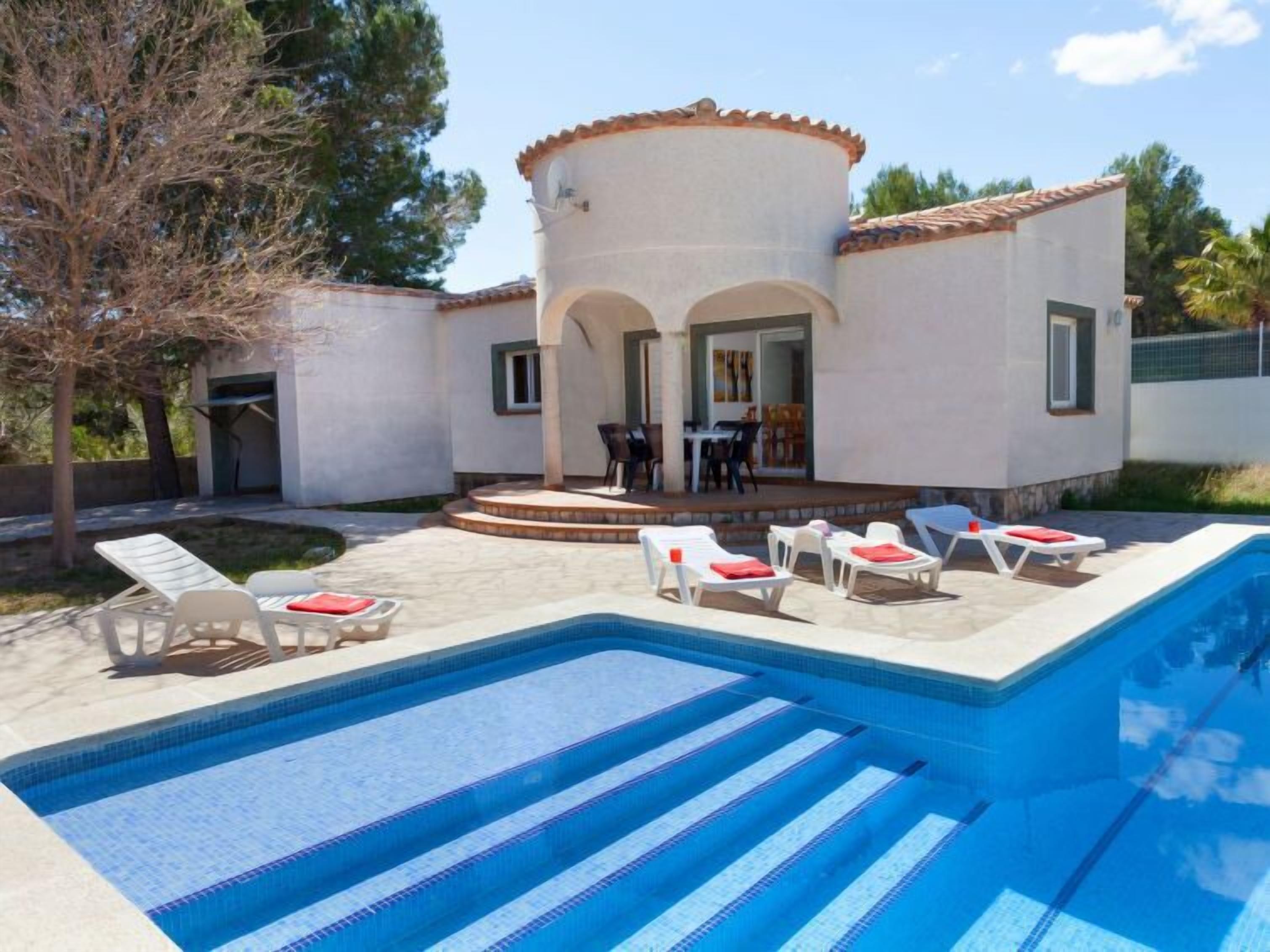 A modern house with a swimming pool, outdoor seating, and a patio area.