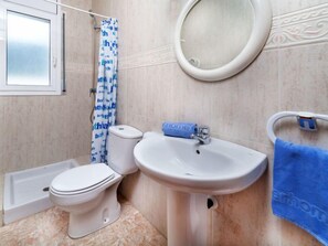 A bathroom with a toilet, sink, and shower.