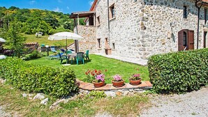 A stone building with a patio area, outdoor seating, and potted plants. - Agriturismo Antee by Interhome (Arcidosso)