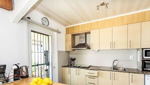 A modern kitchen with wooden cabinets, a granite countertop, a built-in microwave, and a stainless steel sink.
