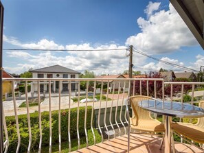 Un balcone con vista su una casa e una piscina.