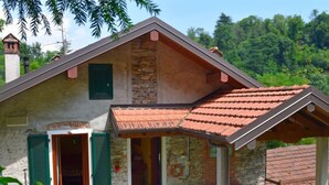 Una casa de piedra rústica con techo inclinado y un porche cubierto.