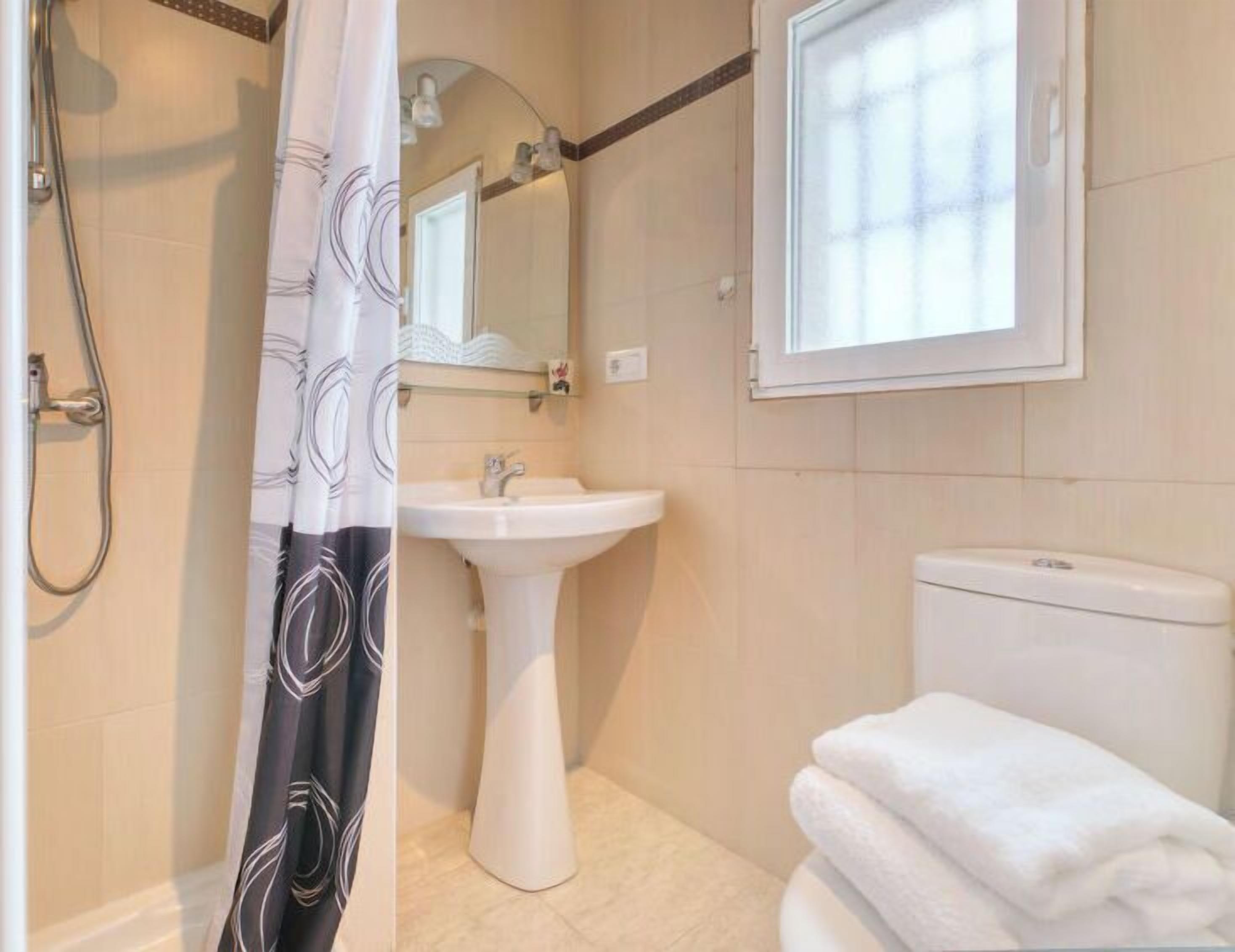 A bathroom with a shower, sink, and toilet.