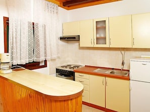 Enjoy cooking in this well-equipped kitchen with a stove, cabinets, and refrigerator.