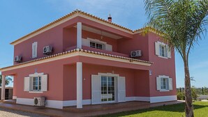 A two-story house with a red facade, white shutters, and a tiled roof. - Das Amendoeiras by Interhome (Alcantarilha)