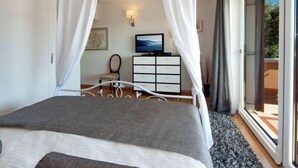 Makuuhuoneessa on sänky, televisio, lipasto ja parveke.