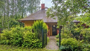 A house with a brick roof, surrounded by dense greenery and a pathway leading to the entrance. - Borowikowa by Interhome (Sasino)