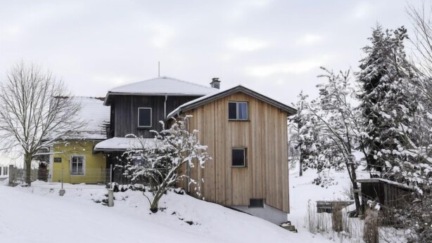 A two-story house with a snow-covered roof and yard. - Kleine Winten by Interhome (Geinberg)