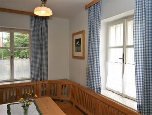 Relax in a cozy seating area with a bench by the window, featuring a large window and a framed picture on the wall.