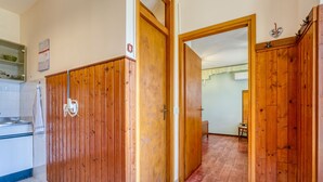 Ein Zimmer mit Holzwänden, einer Küchenzeile mit Spüle und Schränken sowie einem Essbereich mit Tisch und Stühlen.