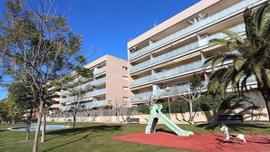 A multi-story building with balconies, a playground with a slide, and a small pool. - Nou Salou by Interhome (Salou)