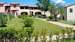 A residential building with multiple balconies, a central courtyard, and a well-maintained lawn.