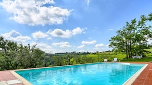 A rectangular swimming pool with a tiled edge, surrounded by a red-tiled deck. - Chiantishire retreat by Interhome (Barberino Valdelsa)