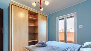 A bedroom with a bed, a wardrobe, and a balcony. - Mario 1 by Interhome (Pula/Krnica)