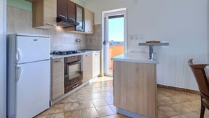 A modern kitchen with a refrigerator, stove, oven, and wooden cabinets. - Mario 1 by Interhome (Pula/Krnica)