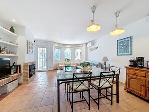 A spacious kitchen with a dining area, large windows, and a fireplace.