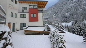 A modern building with a red accent, surrounded by snow-covered trees and mountains. - La Luna by Interhome (Kappl)