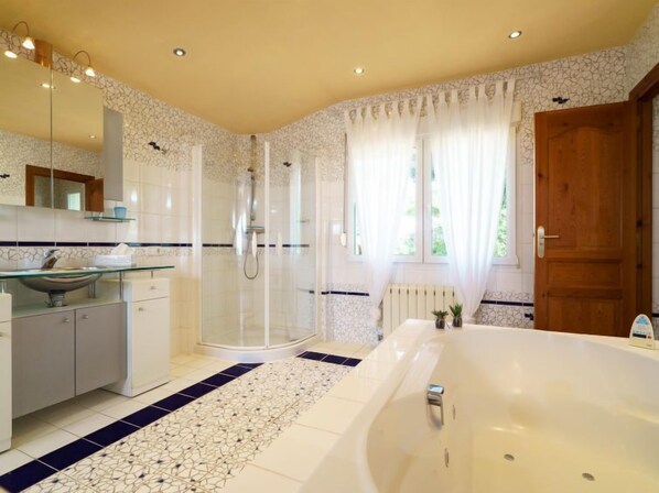 A modern bathroom with a glass-enclosed shower, a freestanding bathtub, and a vanity with a sink. - Bellevue by Interhome (Jávea)