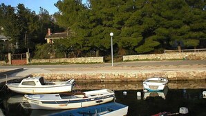 A marina with several boats docked, a stone wall, and a lamppost. - Vacation home Dada by Interhome (Rovanjska)