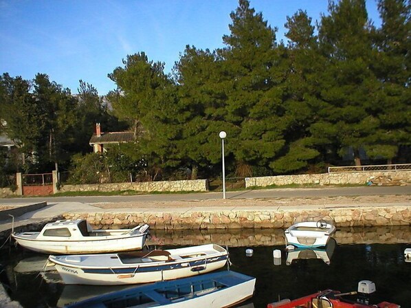 A marina with several boats docked, a stone wall, and a lamppost. - Vacation home Dada by Interhome (Rovanjska)