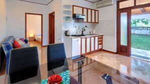 A modern kitchen with wooden cabinets, a dining table with chairs, and a view of the outdoors. - Apartment  Ana by Interhome (Porec/Jehnici)