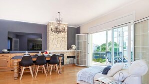 A modern living room with a sofa, a glass coffee table, and a dining area with a table and chairs. - Amsterdam by Interhome (St Antoni de Calonge)