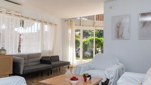 Un salon moderne avec un canapé, des fauteuils et une table basse.