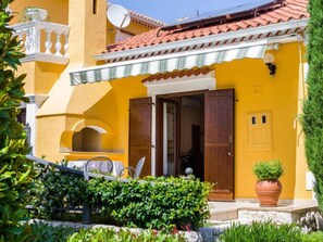 A yellow building with a red-tiled roof, a balcony with white railings, and a door with wooden shutters. - Apartment Stana by Interhome (Zadar)