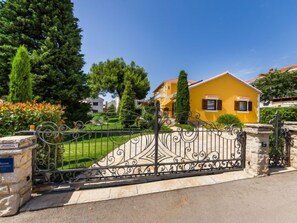 A yellow house with a decorative iron gate in front. - Apartment Stana by Interhome (Zadar)