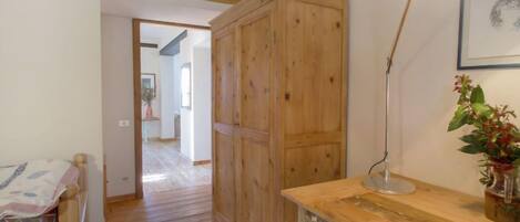 A wooden bedroom with a bed, a desk, and a cabinet.
